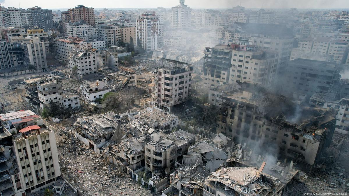 Prédios em ruínas, completamente destruídos, e ainda com fumaça, aparecem em uma cidade da Faixa de Gaza, após ataque aéreo de Israel.