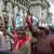 Guatemala-Stadt: demonstrierende Menschen halten Flaggen und geschmückte Rundhölzern in die Höhe
