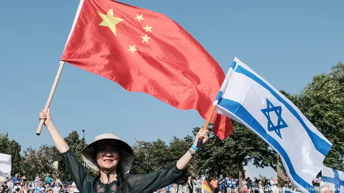 近年来，中以关系逐步趋暖，图为庆祝以色列建国七十周年庆典上有人挥舞中以两国国旗。