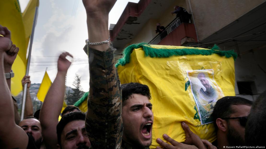  A Hezbollah fighter carries the coffin of his comrade who was killed by Israeli shelling, as he shouts slogans during his funeral procession in Kherbet Selem village, south Lebanon.