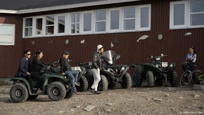 A group of people with four-wheeled motorcycles.