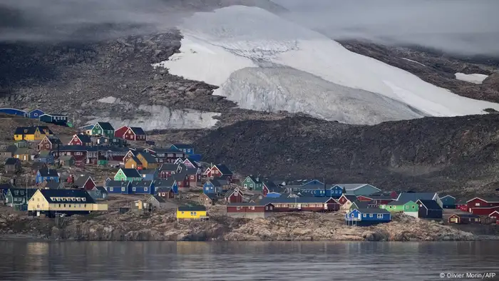 The coastal village Ittoqqortoormiit behind ice covered mountains. 