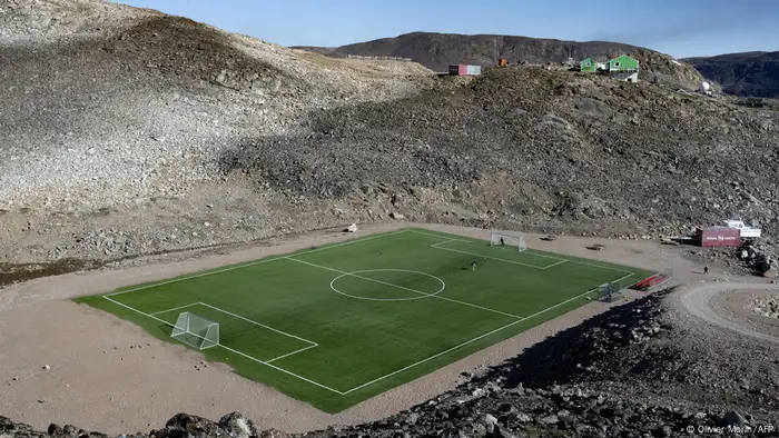 A soccer field with artificial turf among the rocky hills on the outskirts of the village Ittoqqortoormiit 