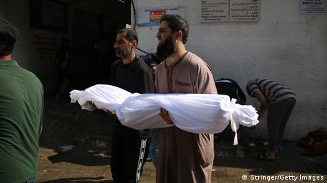 Një burrë duke mbajtur në dorë një të vrarë në Rripin e Gazës