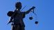 Eine Statue der Justitia steht vor blauem Himmel Eine Statue der Justitia steht vor blauem Himmel