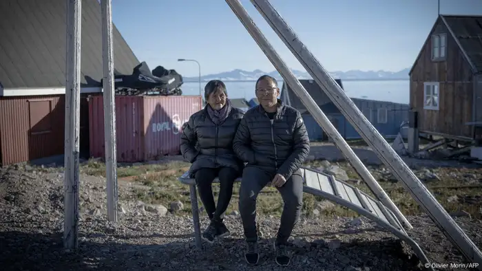 An elderly couple sitting together outside in the low sun in Ittoqqortoormiit