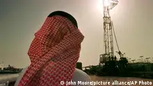FILE - In this Feb. 26, 1997 file photo, Khaled al-Otaiby, an official of the Saudi oil company Aramco, watches progress at a rig at the al-Howta oil field near Howta, Saudi Arabia. Saudi Arabia said on Thursday, Aug. 23, 2018 that it remains committed to an initial public offering of the state-run oil behemoth Saudi Aramco despite delays and growing speculation it may never be listed. (AP Photo/John Moore, File)