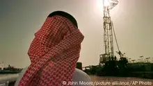 FILE - In this Feb. 26, 1997 file photo, Khaled al-Otaiby, an official of the Saudi oil company Aramco, watches progress at a rig at the al-Howta oil field near Howta, Saudi Arabia. Saudi Arabia said on Thursday, Aug. 23, 2018 that it remains committed to an initial public offering of the state-run oil behemoth Saudi Aramco despite delays and growing speculation it may never be listed. (AP Photo/John Moore, File)