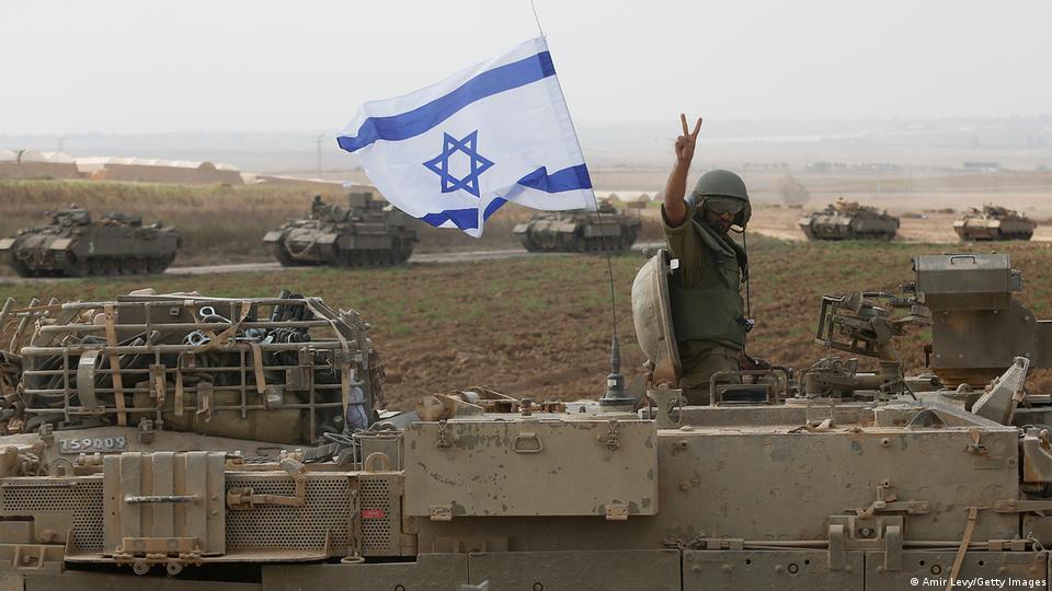 Soldado acena de cima de tanques de combate com bandeira israelense