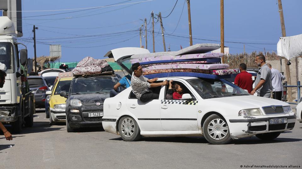 Personas en sus vehículos con sus pertenencias en Gaza.