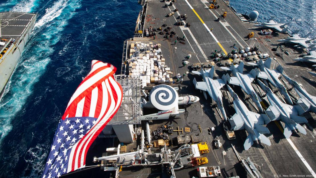 Blick von der Brücke auf das Flugzeugdeck der USS Dwight D. Eisenhower, am Bildrand weht eine US-Flagge