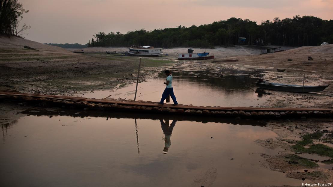 Homem atravessa ponte improvisada em rio que secou no Amazonas