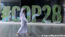 A person walks past a #COP28 sign during The Changemaker Majlis, a one-day CEO-level thought leadership workshop focused on climate action, in Abu Dhabi, United Arab Emirates, October 1, 2023. REUTERS/Amr Alfiky