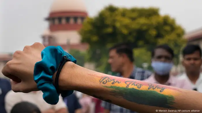 A person displays a tattoo on their arm which reads Born this way at a demonstration in New Delhi