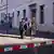 Um casal caminha em direção a um centro judaico em Berlim com uma guarita da polícia