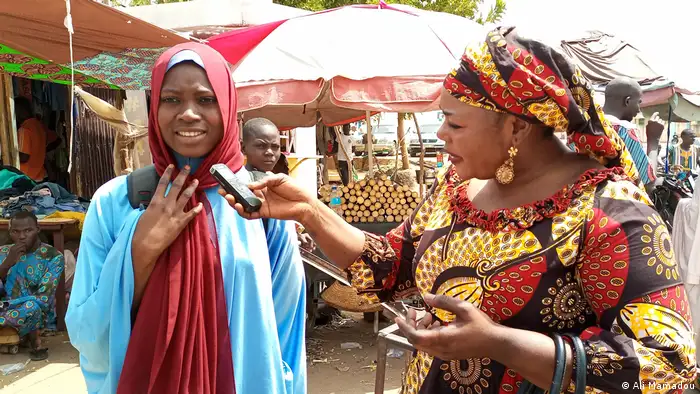 A journalist interviews a woman on a market in Dosso, Niger.