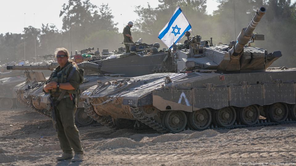 Tanques, uno de ellos con la bandera de Israel, esperan la orden de atacar.