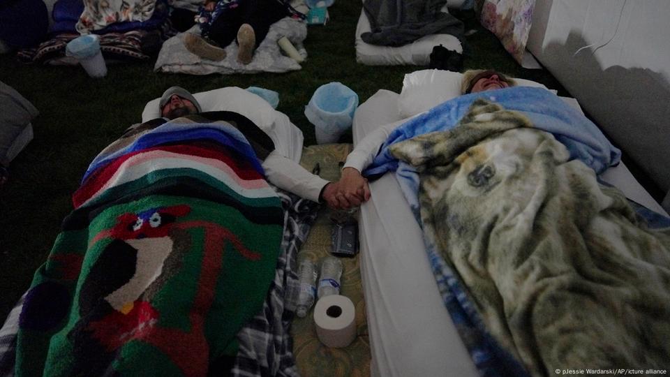 Dos personas se toman de la mano durante una sesión de respiración en el retiro de ayahuasca de la Iglesia del Colibrí en Hildale, Utah.