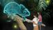 Two girls stand in front of a 3D projection of a chameleon Two girls stand in front of a 3D projection of a chameleon