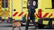A police officer and a bomb sniffing dog in front of bright yellow emergency services vehicles A police officer and a bomb sniffing dog in front of bright yellow emergency services vehicles