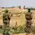 Два боевика "Бригад аль-Кассам" стоят на границе с сектором Газа