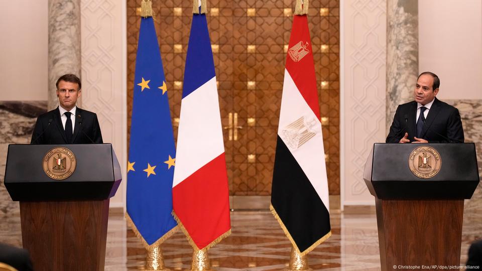 Macron escucha la intervención de Al Sisi desde sendos atriles con las banderas de la Unión Europea, Francia y Egipto entre ellos.