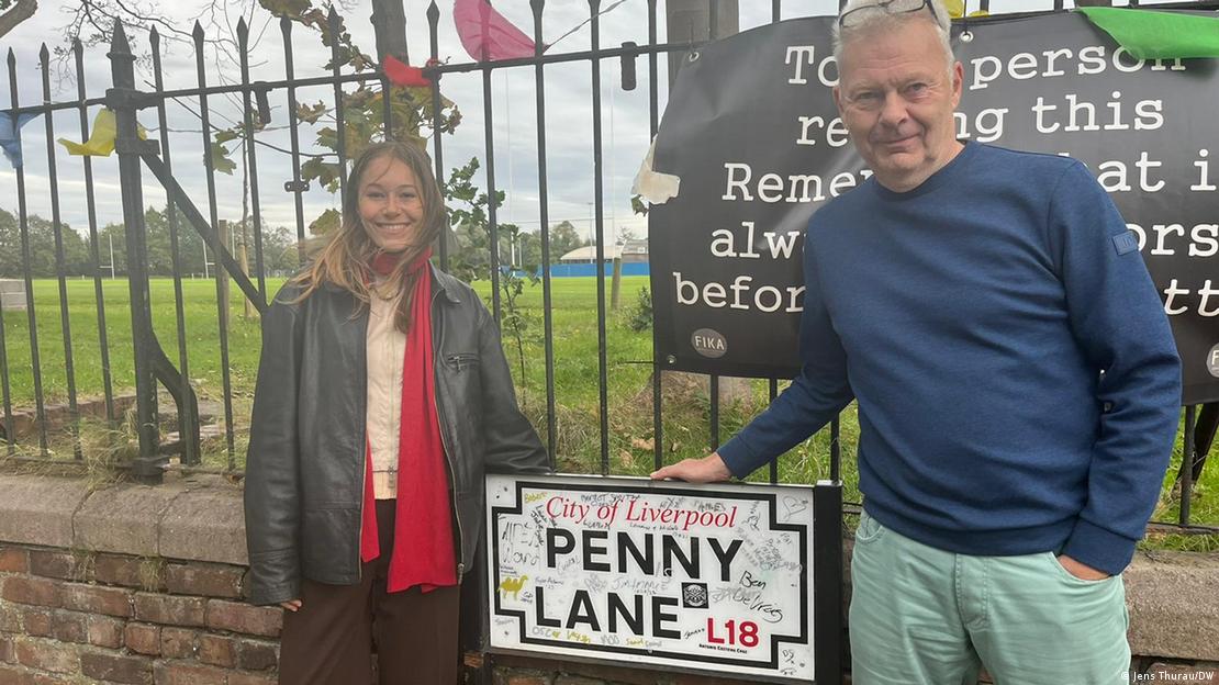 O jornalista Jens Thurau posa para foto ao lado de sua filha diante de placa da rua Penny Lane, em Liverpool.
