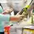 Una mujer agarra una botella de aceite de oliva de un mostrador del supermercado.