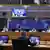 Президент Украины Владимир Зеленский на мониторе в зале заседаний Европейского совета в Брюсселе