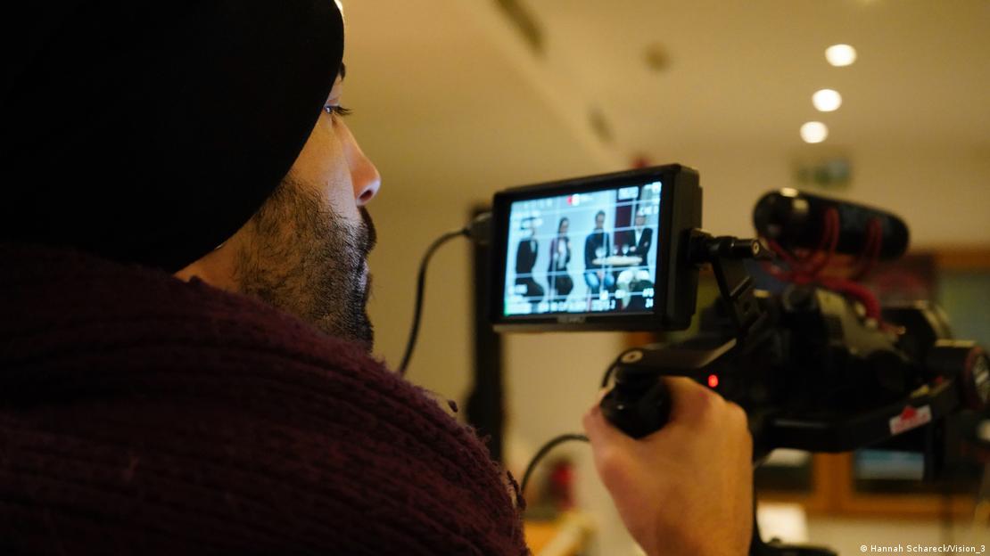 Fotógrafo mira a través de su cámara panel de escritores