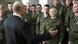 Putin de espaldas hablando con soldados, entre los que destaca una mujer en primera fila. 