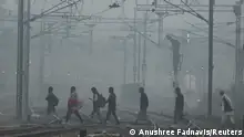 People cross railway tracks on a smoggy morning in New Delhi, India, November 3, 2023. REUTERS/Anushree Fadnavis