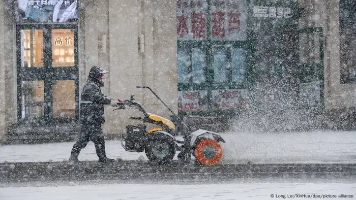 资料照片：沈阳街头清扫路面积雪的工人