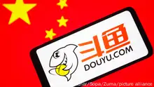 January 28, 2022, Ukraine: In this photo illustration, a DouYu (DouYu.com) logo is seen on a smartphone screen with a flag of China in the background. (Credit Image: © Pavlo Gonchar/SOPA Images via ZUMA Press Wire