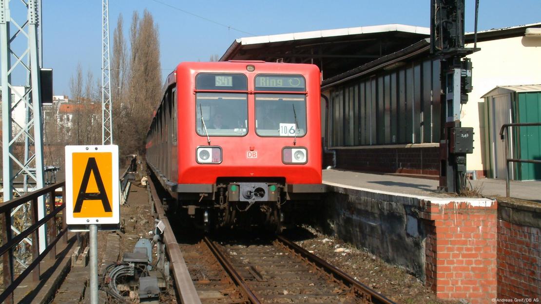 Trena të ndryshëm S-Bahn të parkuar në një stacion me mure me tulla kafe. Trena të ndryshëm S-Bahn të parkuar në një stacion me mure me tulla kafe.