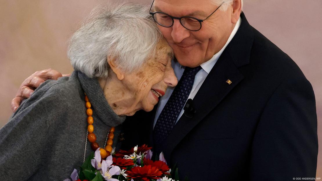 Bundespräsident Frank-Walter Steinmeier hält die Holocaustüberlebende Margot Friedländer in den Armen; Friedländer hält einen Blumenstrauß in den Händen