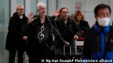 Philadelphia Orchestra's 73-year-old violinist Davyd Booth, second left, waves as he walks ahead of our members upon arriving at the Beijing Capital International Airport on Tuesday, Nov. 7, 2023. Musicians from the Philadelphia Orchestra arrived in Beijing on Tuesday, launching a tour commemorating its historic performance in China half a century ago in signs of improving bilateral ties ahead of a highly anticipated meeting between President Joe Biden and Xi Jinping. (AP Photo/Ng Han Guan)