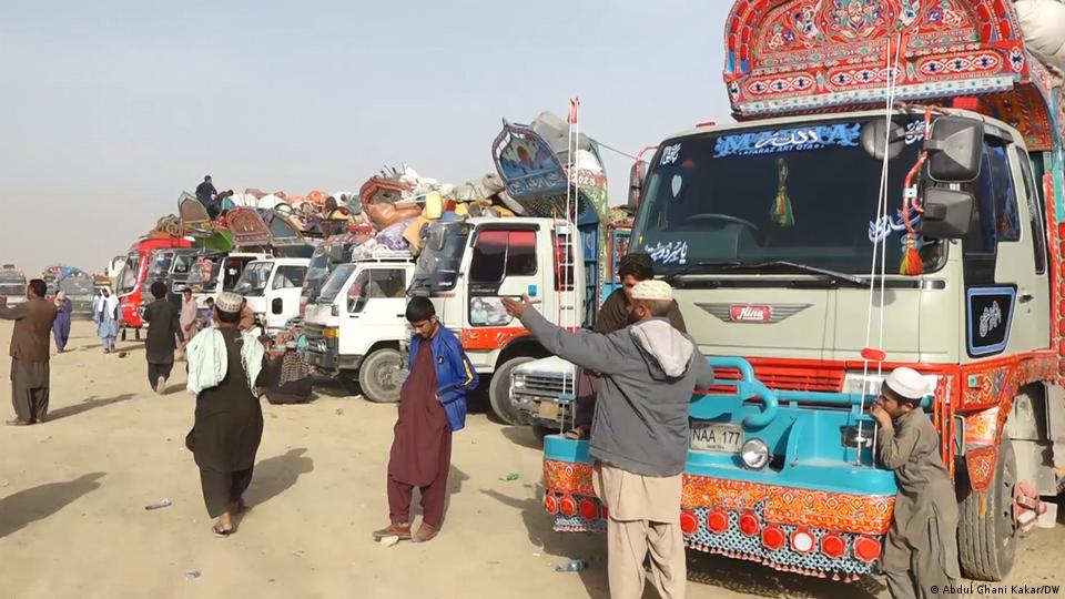 اس تصویر میں چمن کے علاقے میں کھڑے متعدد ٹرک نظر آ رہے ہیں جن پر جلا وطن کیے گئے افغان باشندوں کا سازوسامان لدا ہے