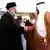 El presidente saudí, ataviado con su tradicional vestuario complementado por un pañuelo palestino, estrecha la mano del representante saudí en las pistas del aeropuerto.