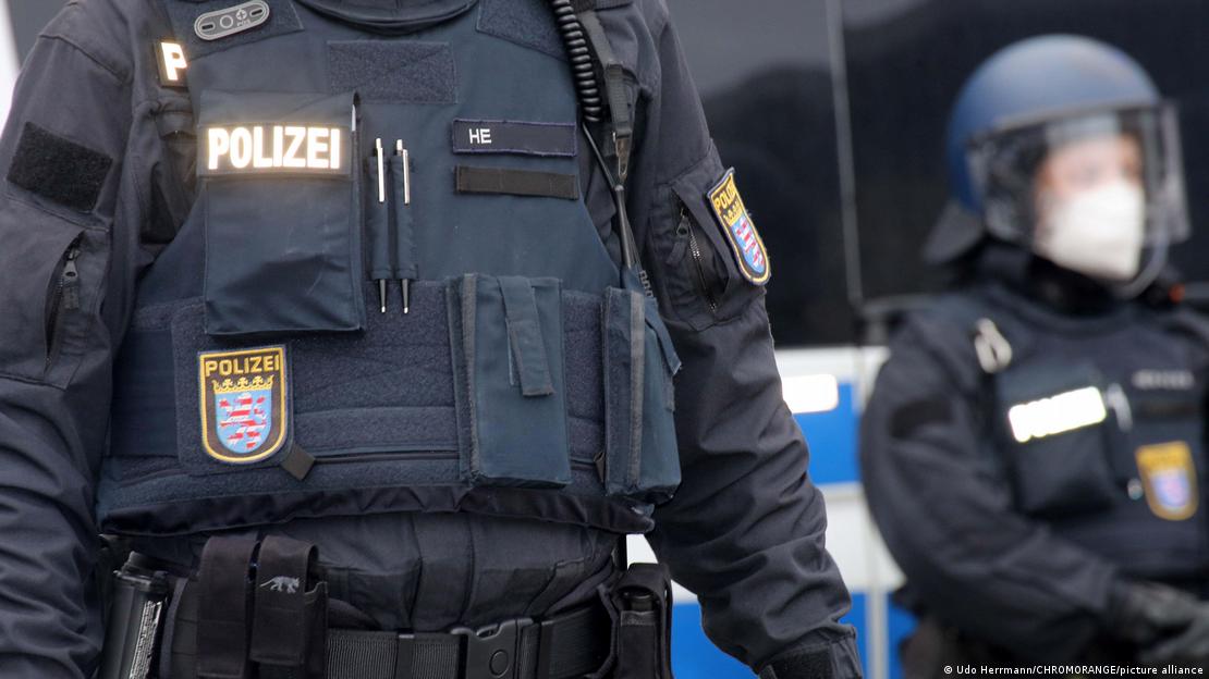 Üzerinde "polis" yazan üniformasıyla iki memur