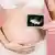 زنی عکس رادیوگرافی حاملگی را نشان می‌دهد