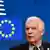  Josep Borrell ante un panel azul con una bandera de la UE.