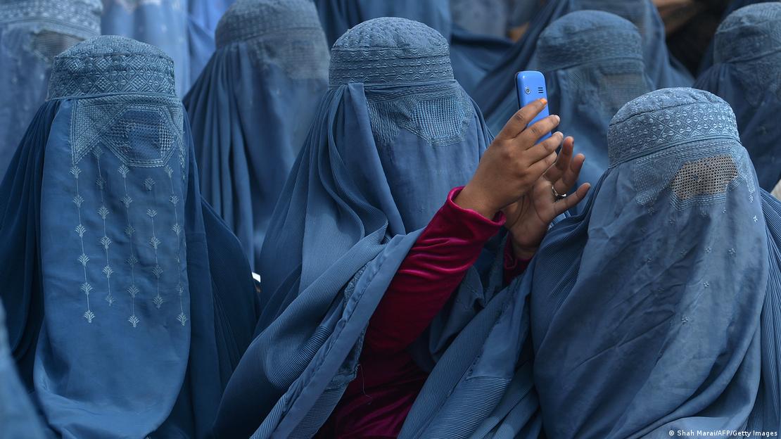 Afganistan'da burka giymiş kadınlar. Biri elindeki telefonla fotoğraf çekiyor. Afganistan'da burka giymiş kadınlar. Biri elindeki telefonla fotoğraf çekiyor.
