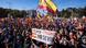 Protesters waving Spanish and EU flags in Madrid, with an extra-large Spanish flag waving tall in the center Protesters waving Spanish and EU flags in Madrid, with an extra-large Spanish flag waving tall in the center