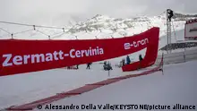 Volunteers mount the finish gate, ahead of the women's downhill race on the new ski course Gran Becca at the Alpine Skiing FIS Ski World Cup Zermatt-Cervinia, in Cervinia, Italy, Sunday, November 19, 2023. The Matterhorn in the background left is hidden by clouds.(KEYSTONE/Alessandro della Valle)