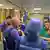 Homens de capacetes azuis com letras UN e com colete conversam com médicos de jaleco verde