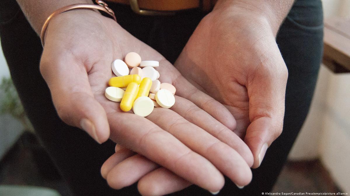 A drug-resistant tuberculosis survivor holds the pills she has to take, in South Africa