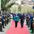 NATO Secretary General Jens Stoltenberg walks down a red carpet with the President of Kosovo, Vjosa Osmani, with soldiers standing to attention on both sides.