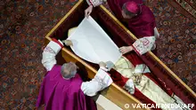前任教宗本笃16世的遗体在梵蒂冈供人瞻仰告别前，两位神职人员在做最后的准备。2013年，本笃16世成为数百年来首位自愿退位的教宗，之前的历任教宗均死在任上。2022年12月31日，约瑟夫·拉钦格在梵蒂冈去世，享年95岁。