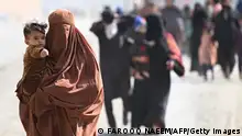 TOPSHOT - Afghan refugee families arrive on foot to cross the Pakistan-Afghanistan Torkham border on November 2, 2023, following Pakistan's government decision to expel people illegally staying in the country. More than 165,000 Afghans have fled Pakistan since Islamabad issued an ultimatum to 1.7 million people a month ago to leave or face arrest and deportation, officials said on November 2. (Photo by Farooq Naeem / AFP) (Photo by FAROOQ NAEEM/AFP via Getty Images)